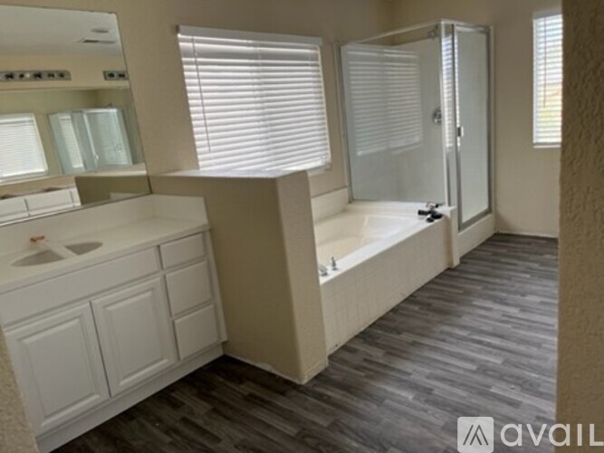A bathroom with a sink, mirror, and bathtub.