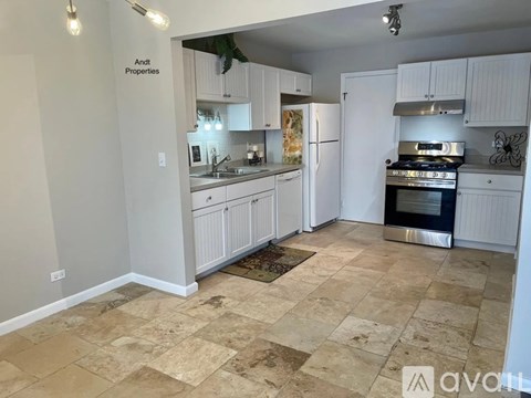 A kitchen with white cabinets and a tiled floor.