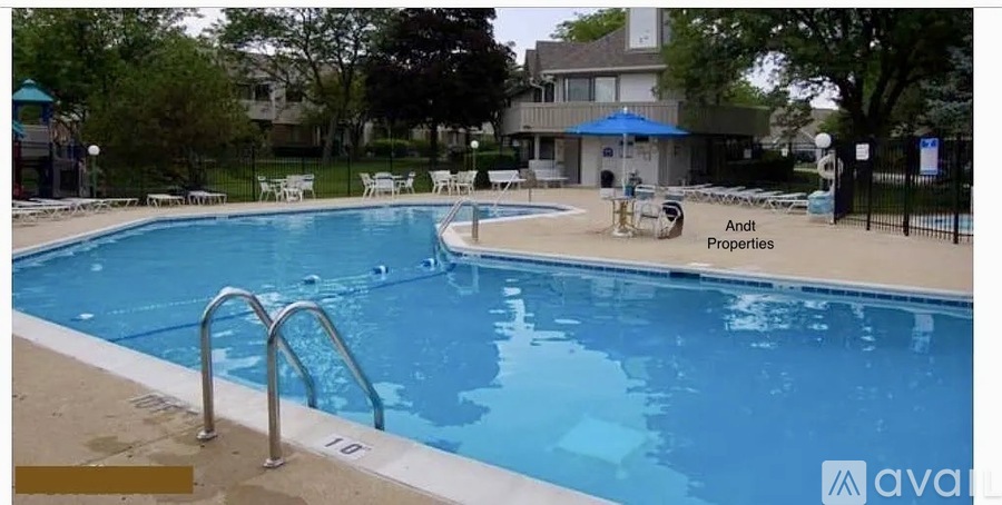 A large swimming pool with a diving board and a water slide.