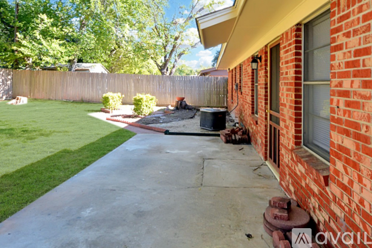 A red brick house with a concrete walkway leading to the front door.