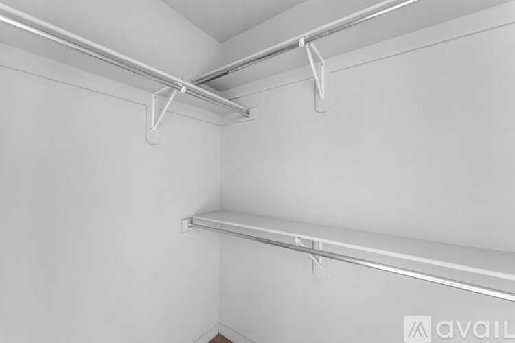 A white wall with a metal rail and two shelves.