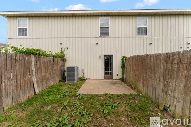 A building with a fence and a door is available for rent.
