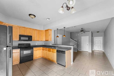 A kitchen with wooden cabinets and black appliances.