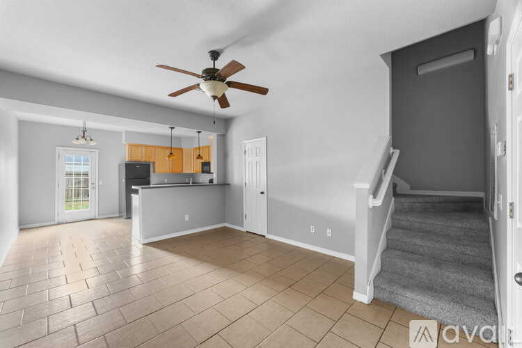A spacious room with a ceiling fan and tiled flooring.