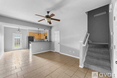 A spacious room with a ceiling fan and tiled flooring.