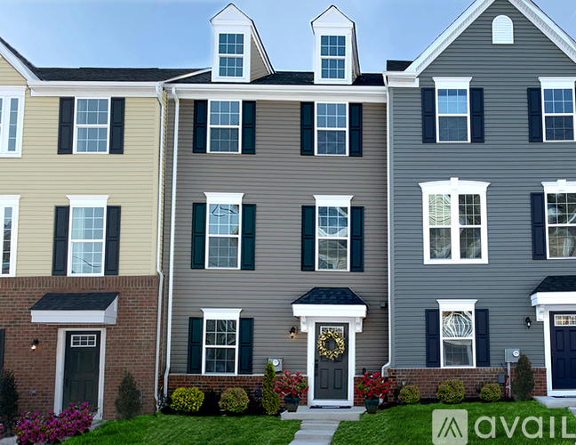 A row of townhouses with different colored front doors.