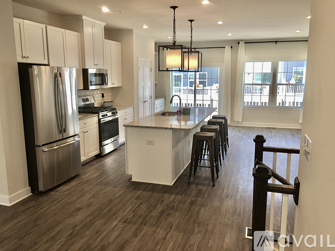 A kitchen with white cabinets and a wooden floor.