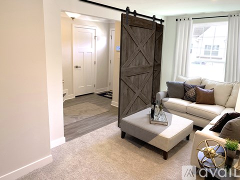 A living room with a white couch and a coffee table in front of a sliding door.