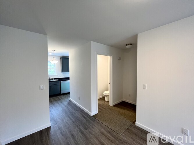 A room with a white wall and a brown rug on the floor.