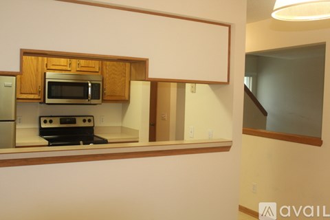 A kitchen with wooden cabinets and a microwave above the stove.