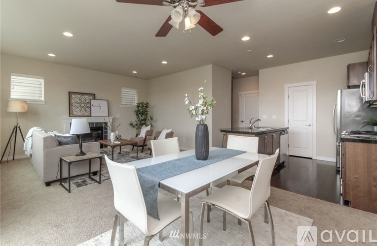 A well-lit dining area with a white table and chairs.