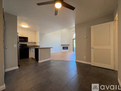 A spacious kitchen with a black oven and a ceiling fan.