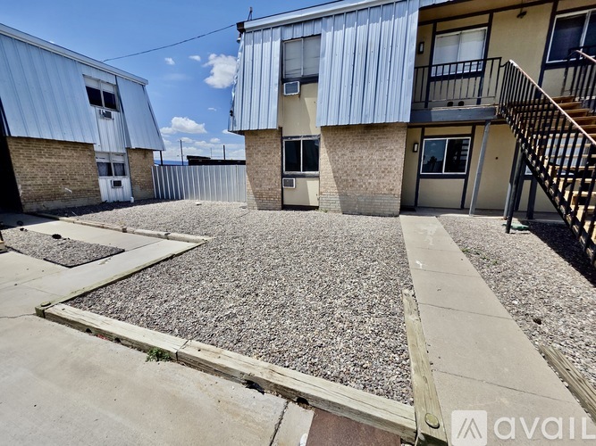 A gravel courtyard is surrounded by apartment buildings.
