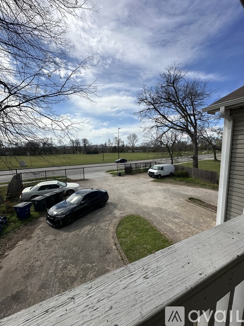 A carport with three cars and a white van parked in it.