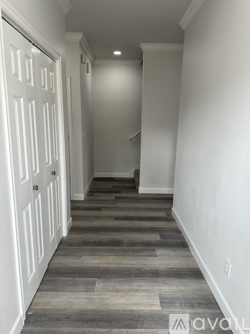 A hallway with a white door and a staircase.