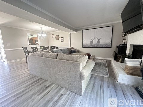 A living room with a grey couch and a fireplace.