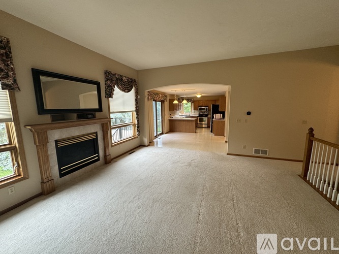 A spacious living room with a fireplace and a television on the wall.