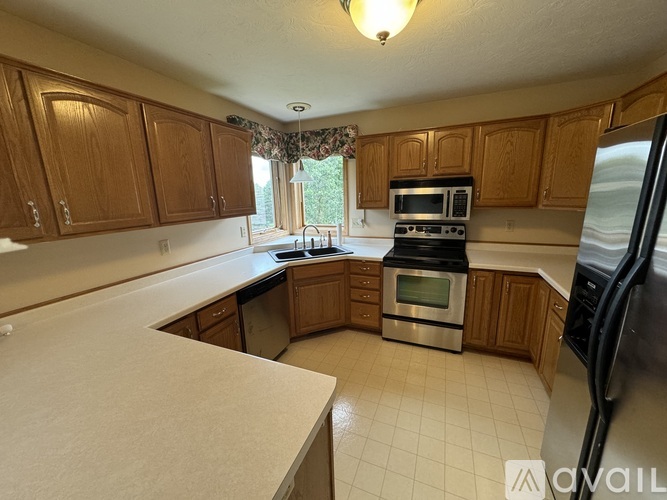 A kitchen with wooden cabinets and a black refrigerator.