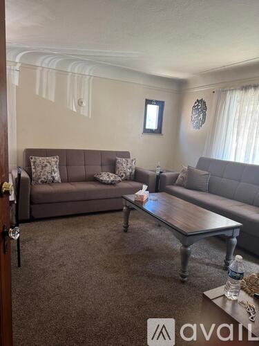 A living room with a grey sofa and a wooden coffee table.