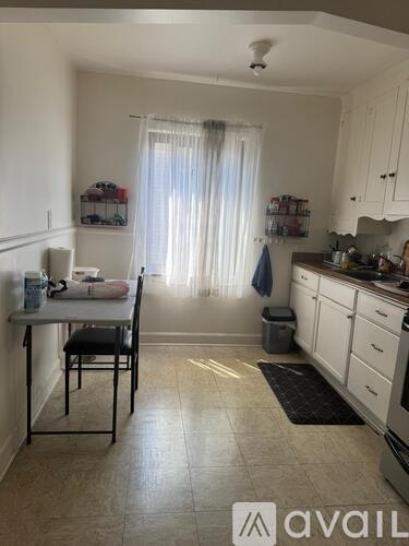 A kitchen with a table and chairs in front of a window.