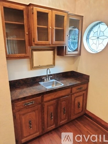 A kitchen with wooden cabinets and a round stained glass window.