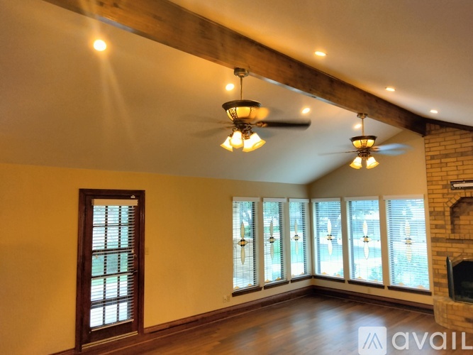 A living room with a ceiling fan and a fireplace.