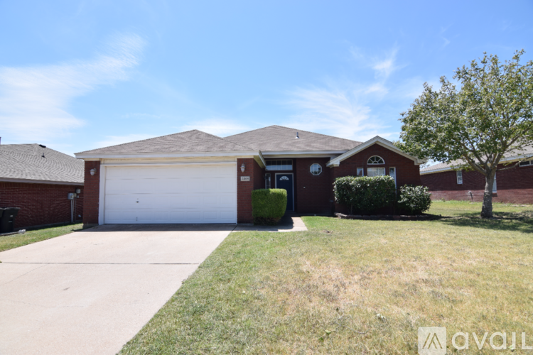 A house with a garage and a tree in front.