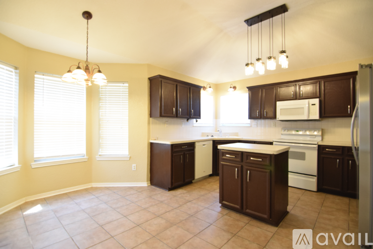 A kitchen with brown cabinets and a white fridge.