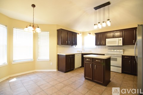 A kitchen with brown cabinets and a white fridge.