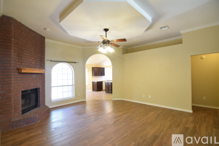 A spacious living room with a fireplace and a chandelier.