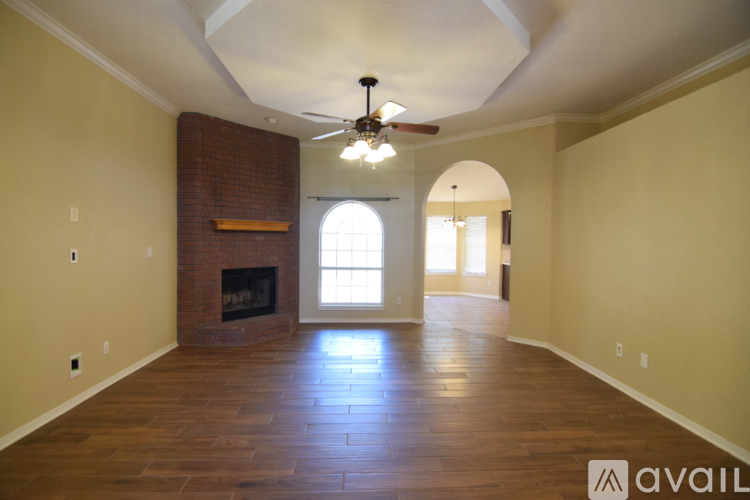 A spacious room with a fireplace and a fan.