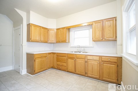 A kitchen with wooden cabinets and a white sink.