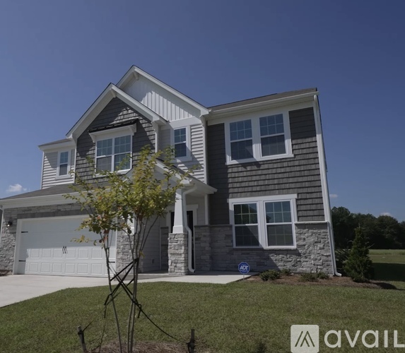 A house with a grey and white exterior and a garage.