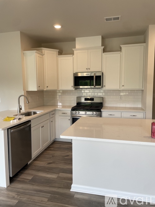 A kitchen with white cabinets and a white island.