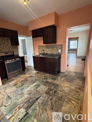 A kitchen with a marble floor and a stove top oven.
