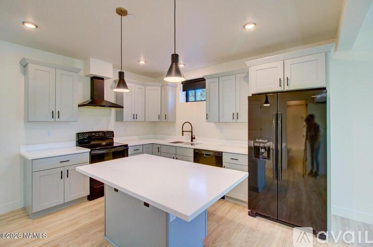 A kitchen with a white island and a refrigerator.