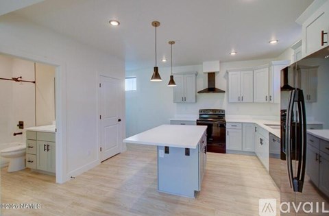 A kitchen with white cabinets and a wooden island.