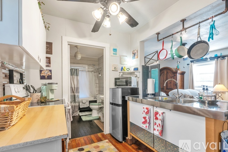 A kitchen with a wooden counter and a fan on the ceiling.