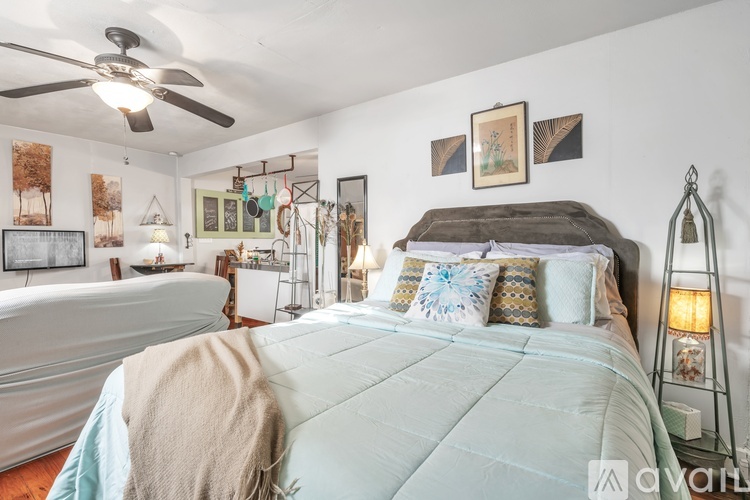 A bedroom with a large bed and a ceiling fan.