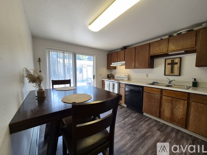 A kitchen with wooden cabinets and a dining table with chairs.