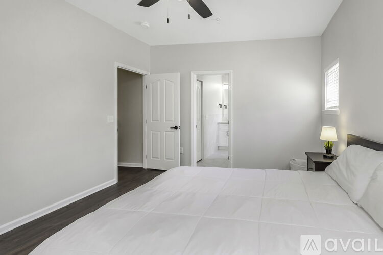 A bedroom with a large bed and a ceiling fan.