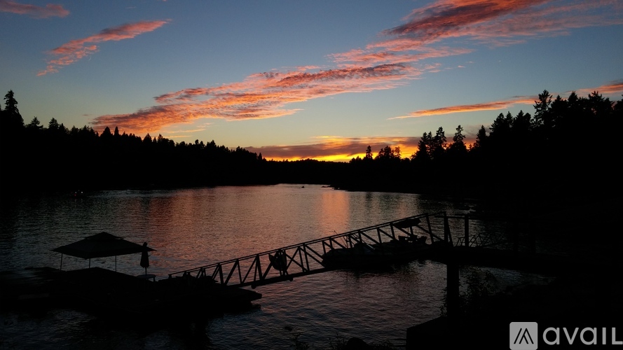 A serene sunset view with a bridge over a calm body of water.