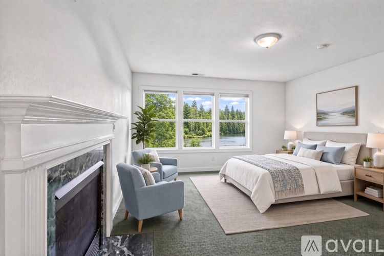 A spacious room with wooden floors and a chandelier hanging from the ceiling.