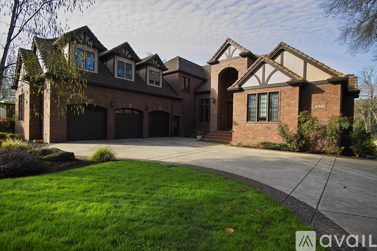 A large house with a driveway in front.