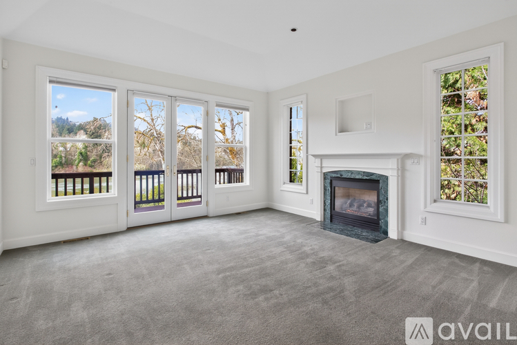 A living room with a fireplace and large windows.