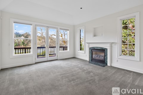 A living room with a fireplace and large windows.