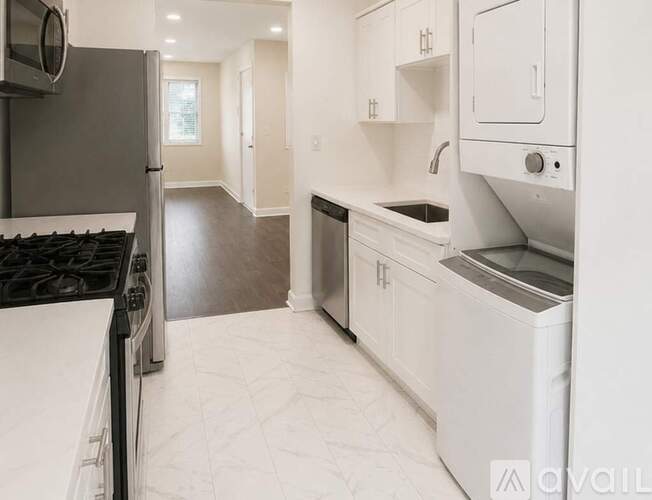 A modern kitchen with white cabinets and appliances.