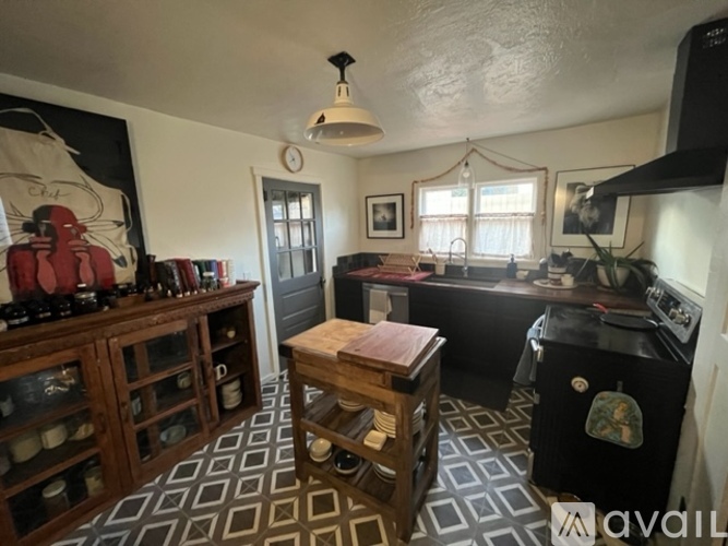 A kitchen with a black stove top oven and a wooden table.
