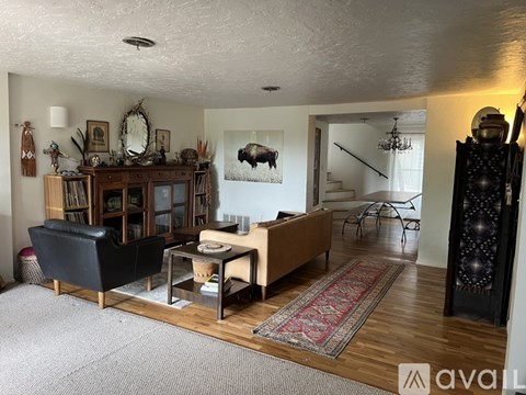 A living room with a black leather chair and a wooden entertainment center.