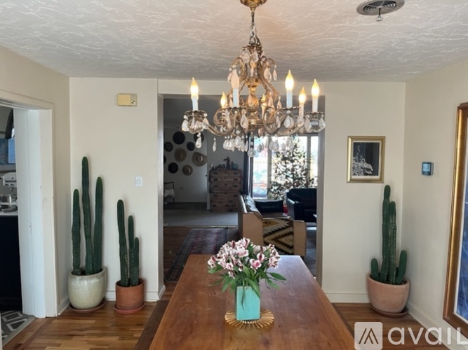 A dining room with a wooden table and a chandelier.